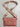 Pink handbag with gold accents on a white background