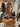 Woman sitting at a table with a gold Finn Scallop handbag by Elyse & i in a casual setting
