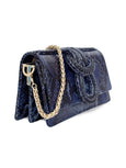 Elyse & i Blue concertina clutch bag with gold chain on a white background