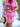 Person wearing a pink dress with white patterns, holding an Elyse & i Mulberry metallic Otis handbag and a straw hat.