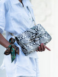Snakeprint leather Elyse & i Theo Knot bag with silk scarf worn on wrist.