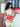 Woman holding a red Theo Knot handbag by Elyse & i in front of a wooden door with glass panels.