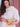 Woman holding a gold Otis handbag by Elyse & i against a pink background
