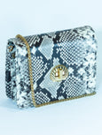 Snake print handbag 'Otis' by Elyse & i with gold chain on a light blue background