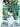 Woman in a white dress standing in front of a green metal fence with plants holding blue Elyse & i Nell knot bag.