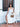 Woman in a white dress holding a cheetah print Finn Scallop clutch by Elyse & i on a tiled patio.