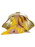 Gold Elyse & i Dawn Scallop clutch with yellow and red patterned fabric on a white background