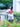 Woman holding a red Elyse & i Finn Scallop bag in a garden setting