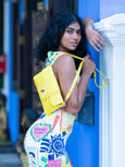 Woman holding a yellow Finn Elyse & i bag against a blue door
