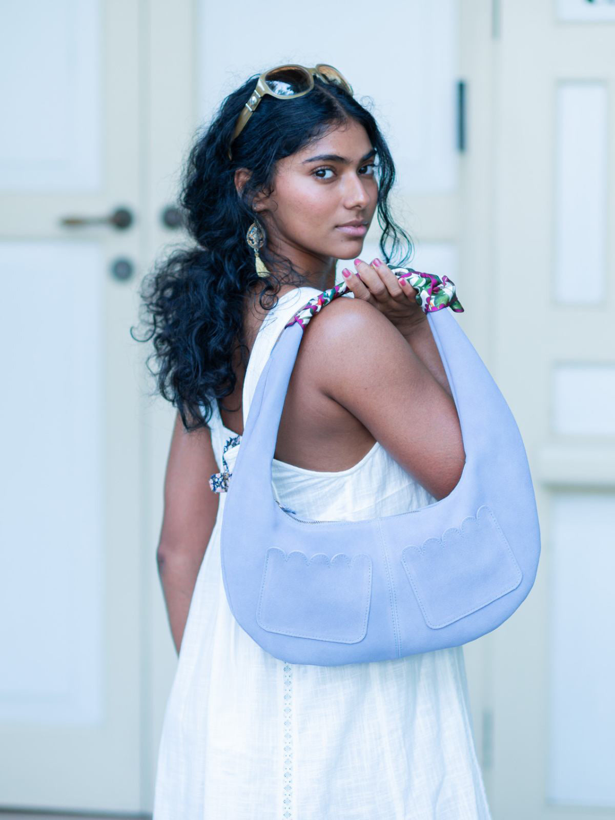 Woman holding a light blue Martha Scallop bag by Elyse & i with a white background