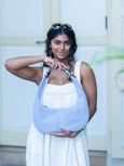 Woman holding a light blue Martha hobo handbag by Elyse & i with a blurred background