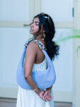 Woman carrying a light blue Elyse & i martha hobo bag with a blurred background