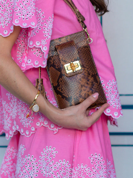 Person holding a brown animal printed handbag by Elyse & i with a pink dress.
