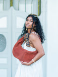 Woman holding a brown Elyse & i Martha hobo bag with intricate patterns against a white background