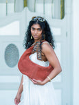 Woman holding a brown Elyse & i Martha hobo bag with a white background