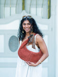 Woman holding a brown Elyse & i Martha hobo bag with a patterned strap against a white background