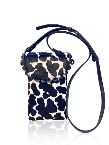 Small pouch with cow print pattern and black strap on a white background