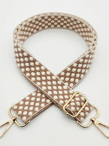 Patterned strap with gold hardware on a white background