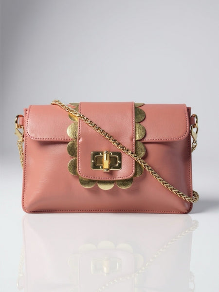 Pink handbag with gold chain strap on a light gray background