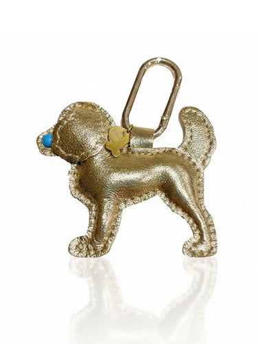 Gold dog-shaped keychain with a blue nose on a white background