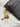 Black wallet with a gold fish charm on a marble surface