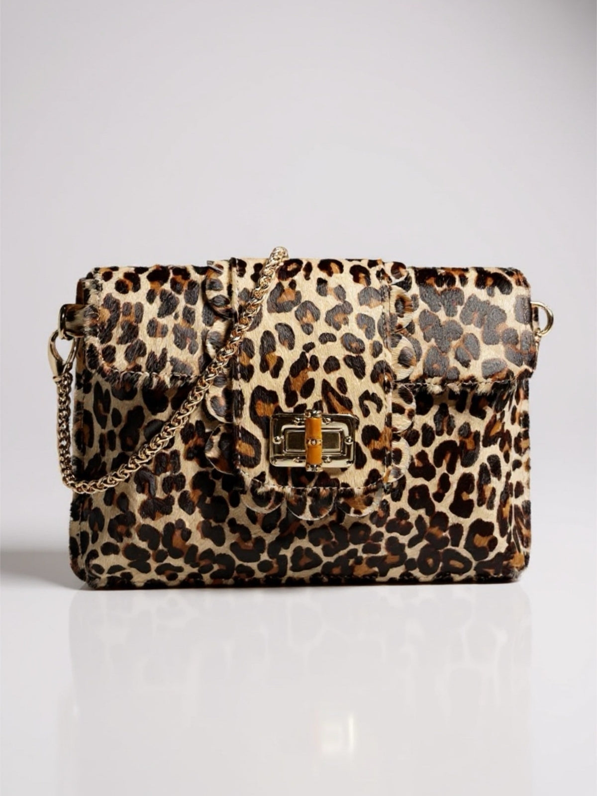 Leopard print handbag with a gold chain on a white background