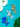 Three colorful dog-shaped charms on a textured blue surface with white flowers and green leaves.