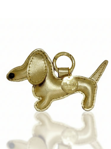 Gold dachshund-shaped charm on a white background