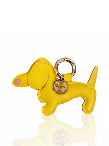 Yellow dog-shaped keychain with a gold tag on a white background