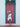 Woman in a white dress standing in front of a red door with teal trim