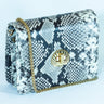 Snake print handbag 'Otis' by Elyse & i with gold chain on a light blue background