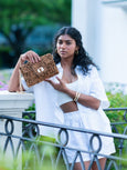 Woman holding a cheetah print Finn Scallop clutch by Elyse & i in an outdoor setting