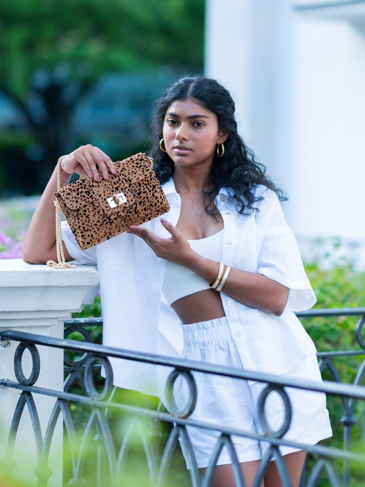 Woman holding a cheetah print Finn Scallop clutch by Elyse & i in an outdoor setting