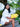 Woman holding a yellow Finn Elyse & i clutch bag outdoors with greenery in the background