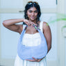 Woman holding a light blue Martha hobo handbag by Elyse & i  with a blurred background