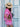 Woman in a pink dress with lace details and a straw hat standing in front of a blue and white door holding a brown snakeprint phone bag by Elyse & i.