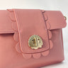 Pink Finn Scallop handbag with shell design clasp on a light background