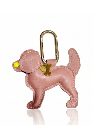 Pink dog-shaped keychain with a gold tag on a white background