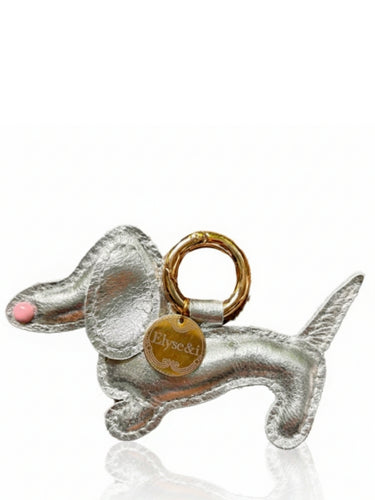 Silver dog-shaped keychain with a gold tag on a white background